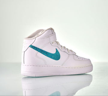 A Nike Air Force 1 high top, with the signature ‘swoosh’ logo bedazzled with  turquoise rhinestones.