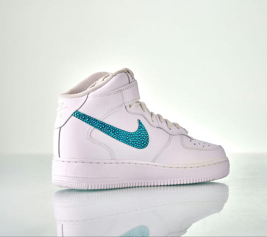A Nike Air Force 1 high top, with the signature ‘swoosh’ logo bedazzled with  turquoise rhinestones.