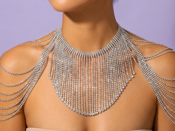 Model wearing an elaborate silver rhinestone fringe necklace with draped crystal shoulder chains.