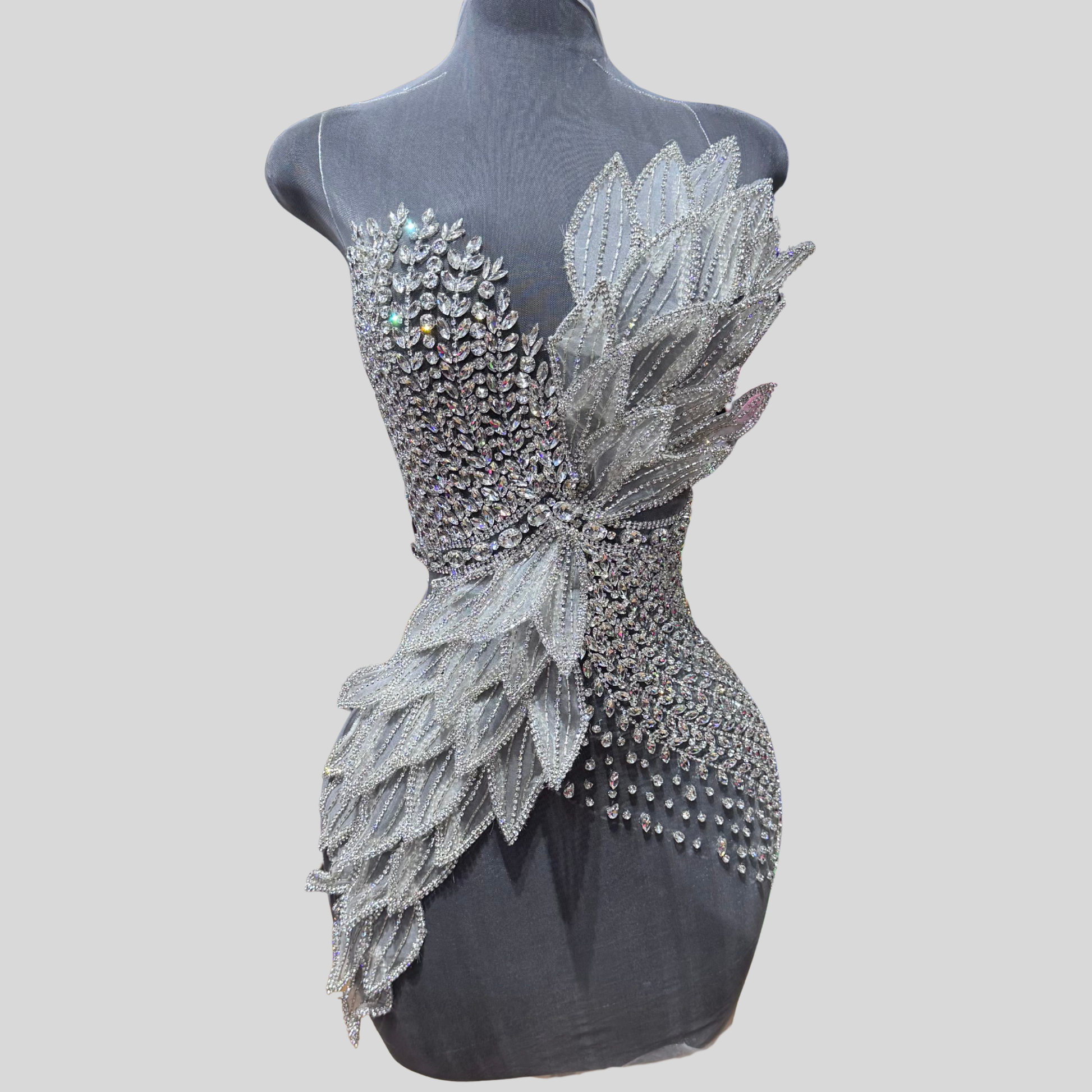 Hand-made rhinestone bodice appliqué with asymmetrical wing-inspired rhinestone detailing on sheer mesh
