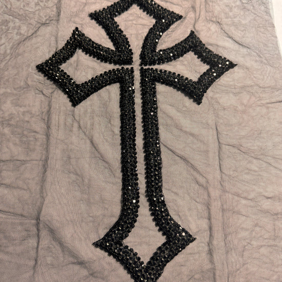 Black cross design with sequins on a gray fabric background