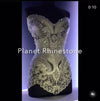 Rhinestone-embellished strapless corset dress displayed on a mannequin, featuring intricate crystal patterns and ornate detailing for a glamorous stage costume.