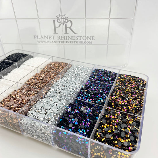 A plastic box containing separate compartments of different colored rhinestones.