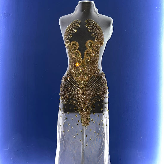 A bodice covered in many gold rhinestones.