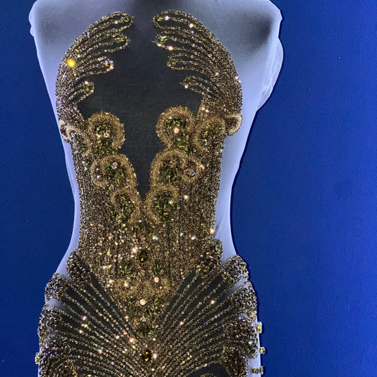 A bodice covered in many gold rhinestones.