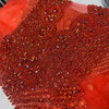 Many red rhinestones on a red net material.