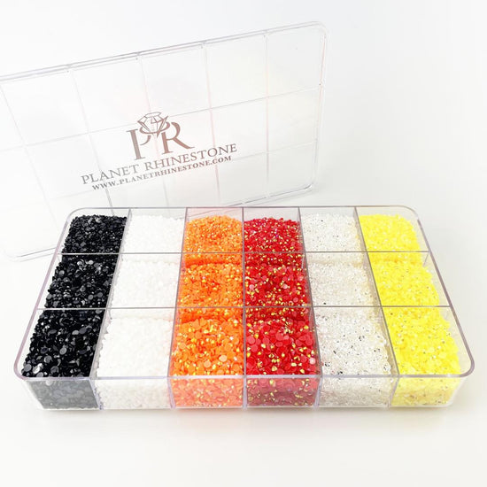A plastic box containing separate compartments of different colored rhinestones.